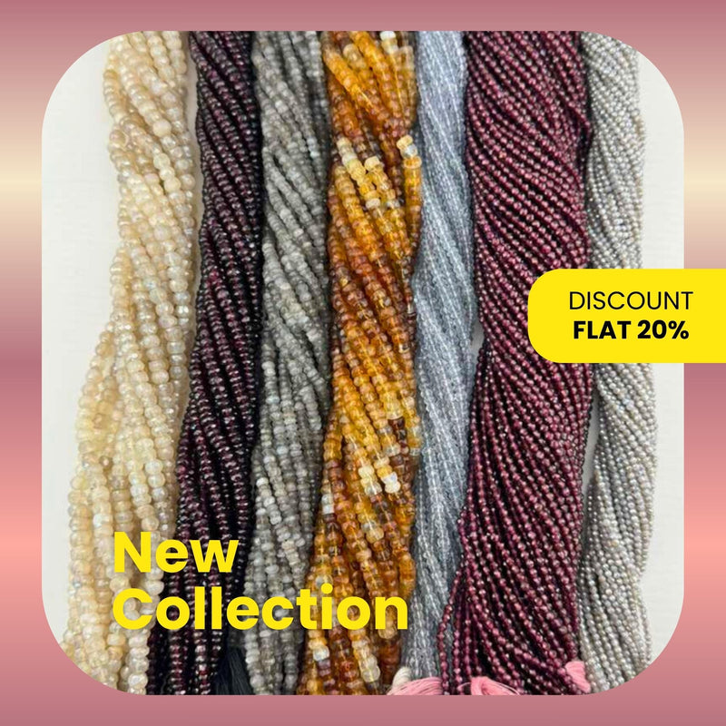 Multiple strands of gray and garnet gemstone beads in rondelle, drop, pipe, coin, drum, and oval shapes on a white background.