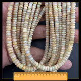 May include: Strands of faceted opal beads in cream, yellow, and pale green hues. The beads are strung together, suitable for a necklace or bracelet. The ruler at the bottom shows a length of 40.6 cm.